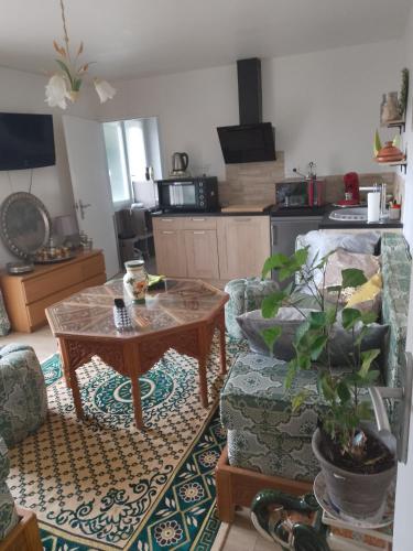 ein Wohnzimmer mit einem Tisch und einem Sofa in der Unterkunft Appartement avec jardin et parking privé in Saint-Gaudens