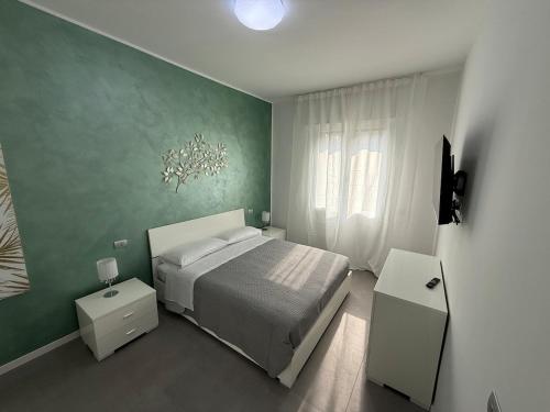 a bedroom with a bed and a green wall at Appartamenti Rugacesio 24 - B in Pioltello