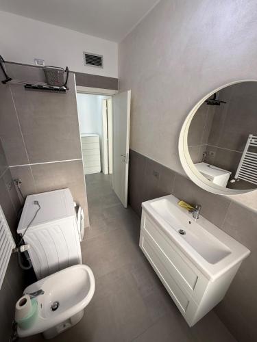 a bathroom with a sink and a toilet and a mirror at Appartamenti Rugacesio 24 - B in Pioltello