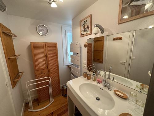 ein Bad mit einem Waschbecken und einem Kühlschrank in der Unterkunft Appartement esprit montagne in Le Lioran