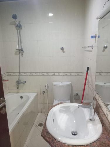łazienka z umywalką, wanną i toaletą w obiekcie سكن مختلط شهري بنات اولاد w mieście Adżman