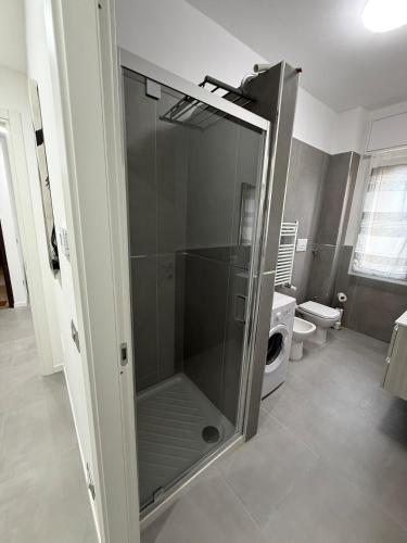 a glass shower in a bathroom with a toilet at Appartamenti Rugacesio 24 - C in Pioltello