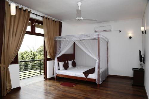 a bedroom with a bed with a mosquito net at Cirute' Talwatte, Kandy in Kandy