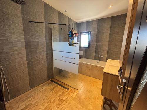 a bathroom with a shower and a sink and a tub at Viviloue in Saint-Pierre-Lafeuille