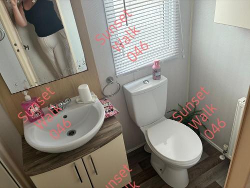 a bathroom with a white toilet and a sink at Sunset Walk 046 in Barmouth