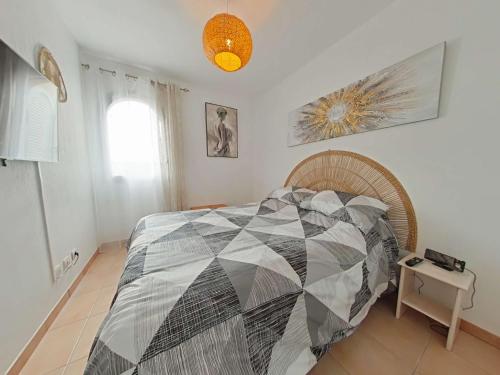 勒卡特海滩Mais 2 pièces 4 couchages PORT LEUCATE NATURISME PL040-040的一间卧室，床上铺着被子