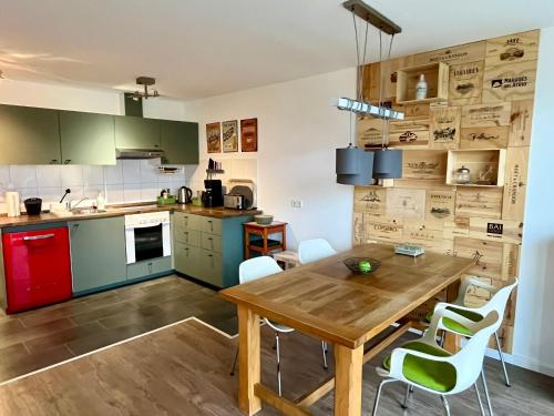 - une cuisine avec une table en bois et des chaises blanches dans l'établissement Küstenliebe, à Heiligenhafen