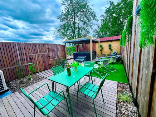 a patio with a table and chairs on a wooden deck at Appart' Zen & connect in Ennevelin