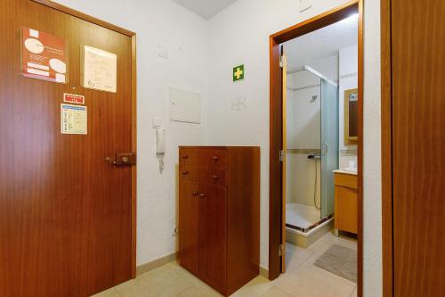 ein Badezimmer mit Holztür und einem Schrank in der Unterkunft Campo Mar - T1 vista praia in São Martinho do Porto