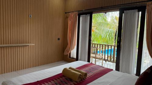 une chambre avec un lit et une grande fenêtre dans l'établissement Gelih Bungalow Nusa Penida, à Nusa Penida