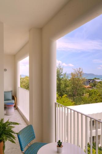 a balcony with a table and chairs and a large window at The Standard, Pattaya Na Jomtien in Na Jomtien