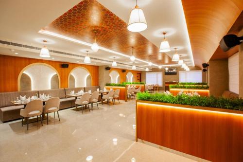 a restaurant with tables and chairs in a room at Hotel dreamland residency in Kottayam