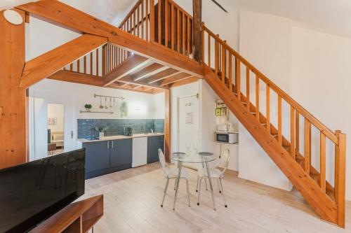eine Küche und ein Esszimmer mit einem Tisch und einer Treppe in der Unterkunft Appartement 1 chambre mezzanine centre de Roubaix in Roubaix