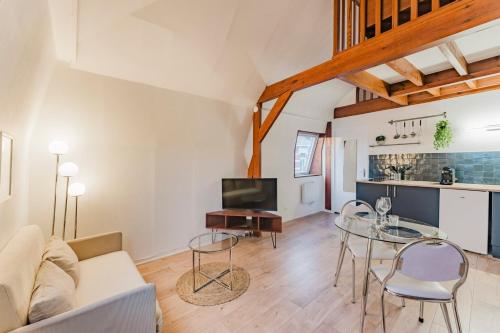 ein Wohnzimmer mit Sofa und Tisch in der Unterkunft Appartement 1 chambre mezzanine centre de Roubaix in Roubaix