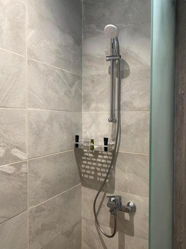 a shower with a shower head in a bathroom at Sunset Hotel for Hotel Services in Najran