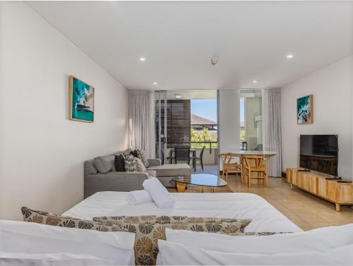 a bedroom with two beds and a living room at Coastal Bliss Studio - Santai 224 in Casuarina