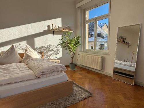 a bedroom with a bed and a large window at Altstadt Studio Sankt Annenblick in Annaberg-Buchholz