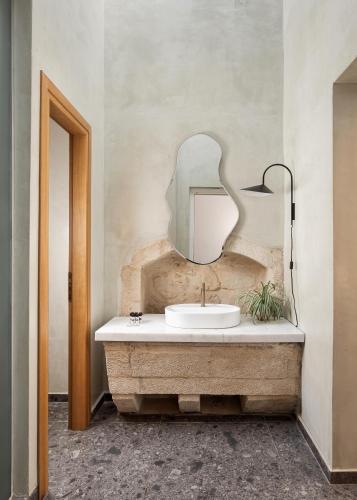 a bathroom with a sink and a mirror at Civitas Suites Hotel in Rethymno
