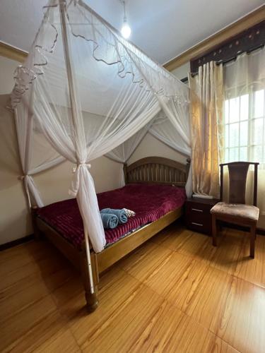 1 dormitorio con cama con dosel y suelo de madera en house with a garden, en Kampala