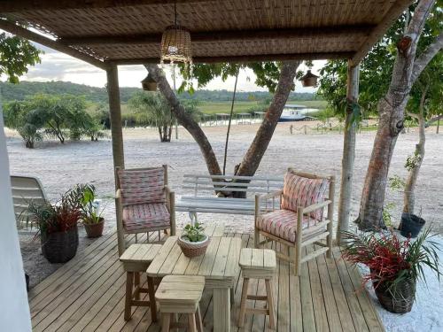 una terrazza in legno con 2 sedie e un tavolo di Container Vermelho na beira do rio e a poucos metros do mar com cozinha completo a Belmonte