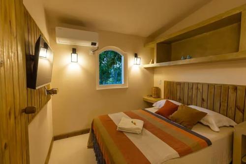 una camera da letto con un letto e una finestra di Container Vermelho na beira do rio e a poucos metros do mar com cozinha completo a Belmonte