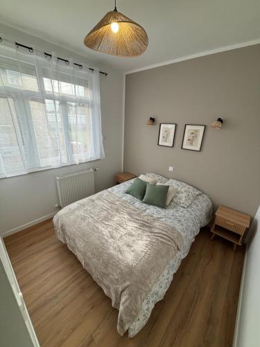 a bedroom with a bed and a large window at Les meublés de l Etoile in Eu