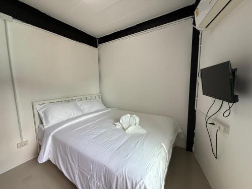 ein Schlafzimmer mit einem weißen Bett mit einer Schleife darauf in der Unterkunft Flow Stay Koh Samet I10 流宿沙美島 雙人房 Double room, private bathroom, 2-5mins walk distance to pier and everywhere in Ko Samed