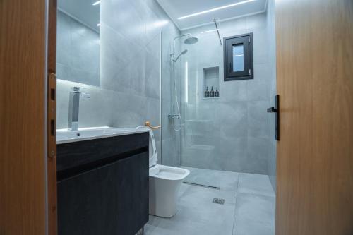 Un baño con ducha, inodoro y lavabo. en λαλώ, en Órma