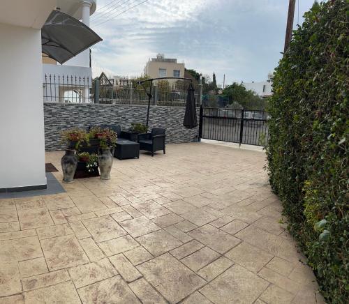 a patio with plants and a stone wall at Maria’s studio in Paphos City
