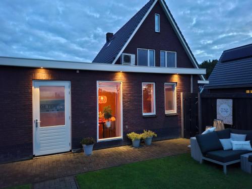 a house with a patio with a couch at B&B De Terpen in Dokkum