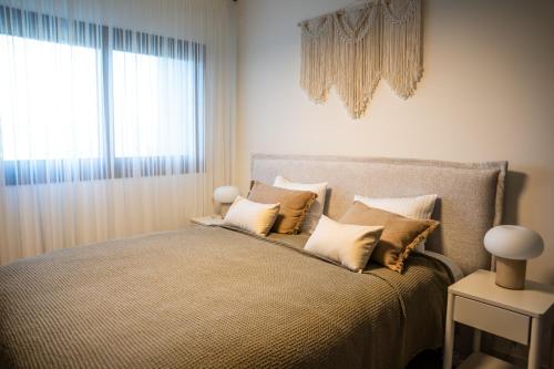 a bedroom with a bed with pillows and a window at Luxe One Residence in Aglantzia