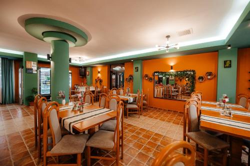 a restaurant with wooden tables and chairs and a mirror at Pensiunea Vanatorul in Vatra Dornei