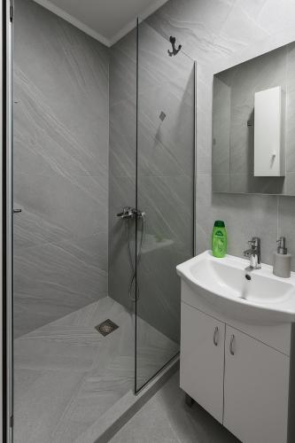 a bathroom with a shower and a sink at 3 Stars Apartments in Prilep