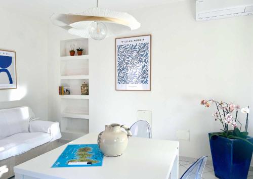 a white living room with a vase on a table at Il giardino di Gaia in Portoferraio