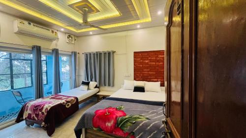 Una habitación de hotel con dos camas y una ventana. en YOU and I CAFE, en Varanasi