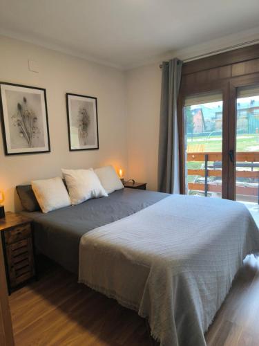 a bedroom with a large bed and a window at Lybica Green "Enclavament de Llívia" in Llivia