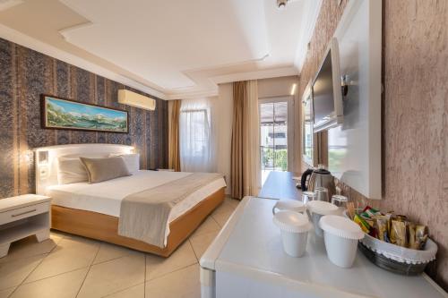 a hotel room with a bed and a sink at Nicholas Park Hotel in Oludeniz