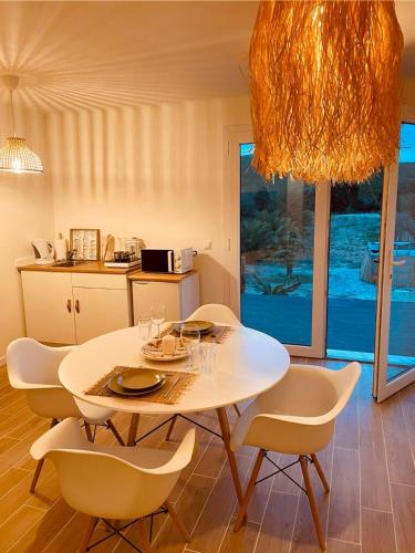 a dining room with a white table and chairs at Maçussa Country House in Massuça