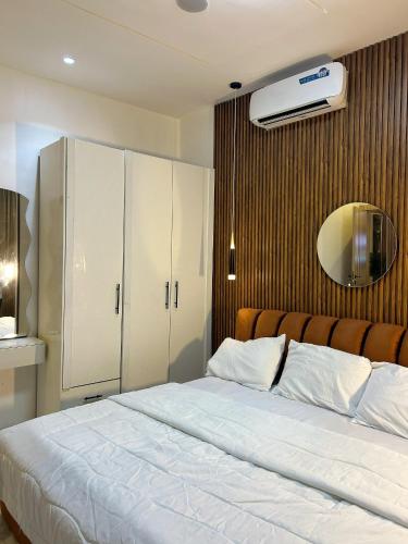 a bedroom with a white bed and a white cabinet at Shortletbylolami in Mama