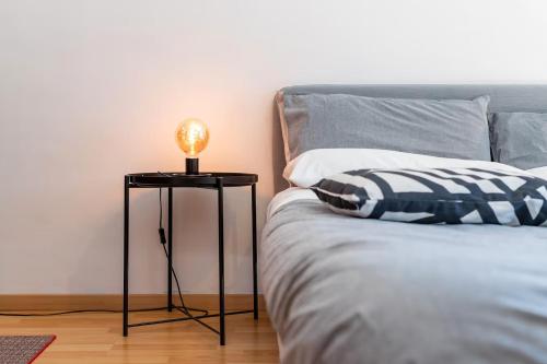 a lamp on a side table next to a bed at La stanza Modicana in Modica