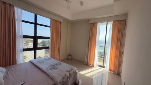 a bedroom with a bed and a large window at Sea View Apartment in Colombo -Dehiwala in Dehiwala