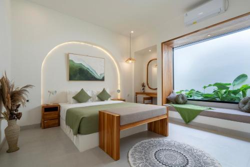 a bedroom with a bed and a large window at Tanahlot Beachview Rooftop Villa in Tanah Lot