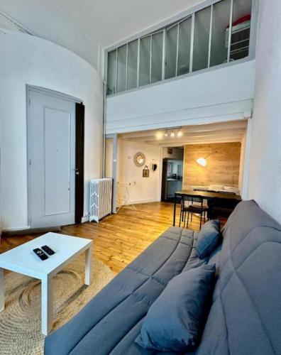 Duplex république في لو بوي: غرفة معيشة بها أريكة زرقاء وطاولة