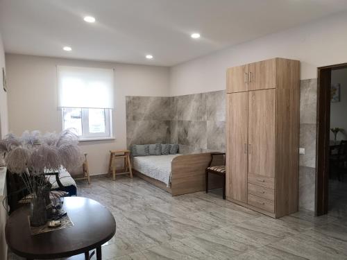 a bedroom with a bed and a wooden cabinet at Butas pačiame miesto centre in Telšiai