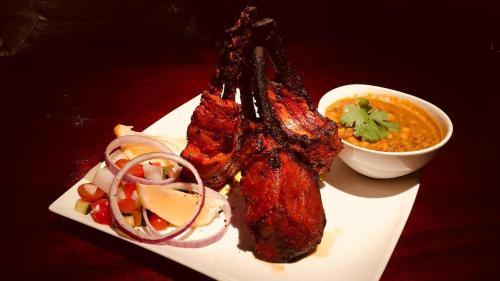 a plate of food with meat and a bowl of soup at The Arches- Beautiful 3-Bedroom Family Stay Near Adelaide Oval, City Events and Amazing Dining in North Adelaide