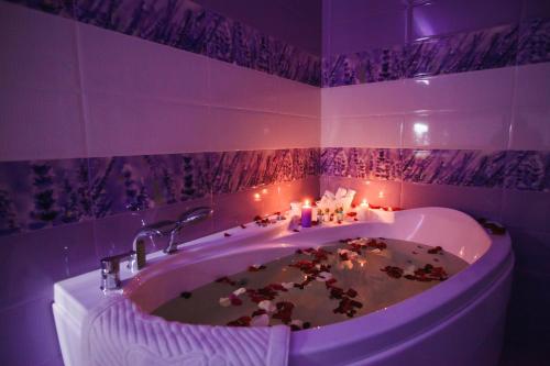 a purple bathroom with a bath tub with candles at Sport Hotel Maximum in Kemerovo