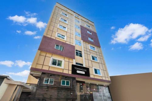 a tall building with a sign on the side of it at POP 84109D Hotel O Near Jodimetla X Roads in Kukatpalli