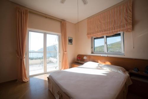 a bedroom with a bed and a large window at Ourdreamhouses Lake Hereou Loutraki in Vouliagmeni Lake