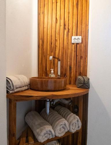 a bathroom with a sink and some towels on a shelf at Índico Breeze in Praia do Tofo