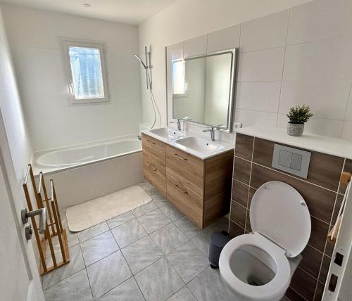 ein Badezimmer mit Toilette, Waschbecken und Badewanne in der Unterkunft Maison cosy - Logis Flo - à 15 min du Futuroscope in Beaumont